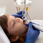 a little boy is getting dental treatment